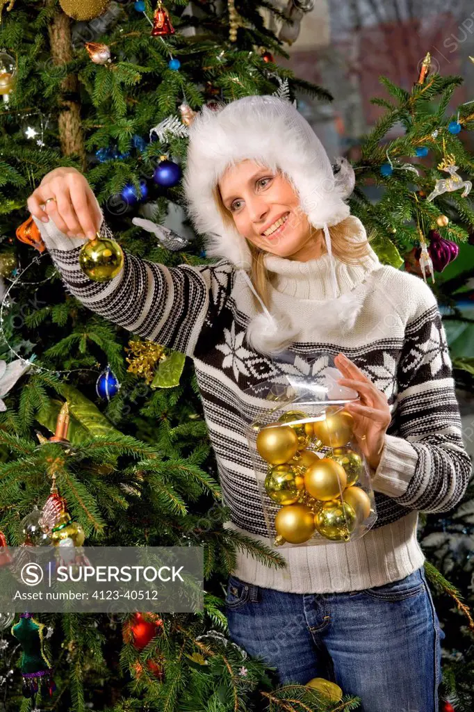 Woman decorating Christmas tree.