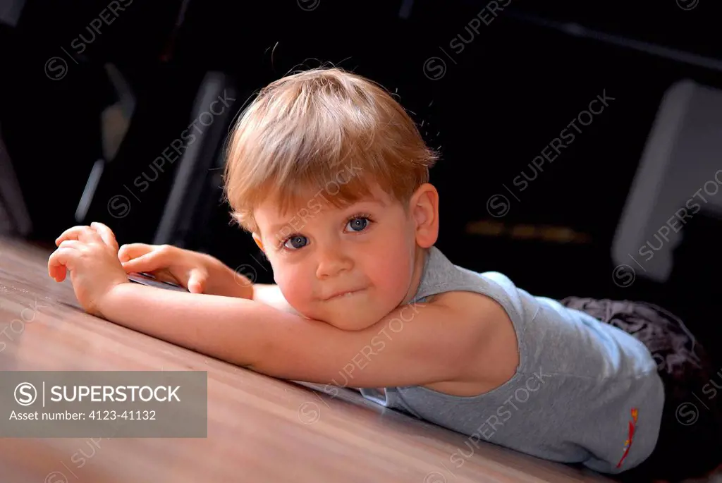 Little boy lying on the floor.