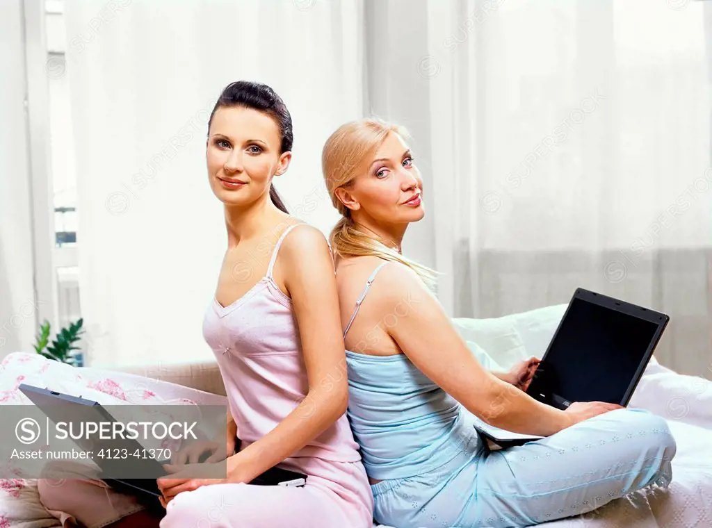 Mother and daughter while working with laptops