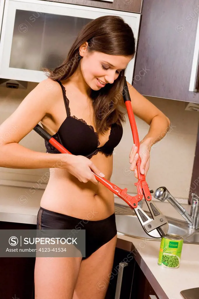 Woman wearing underwear, trying to open a tin.