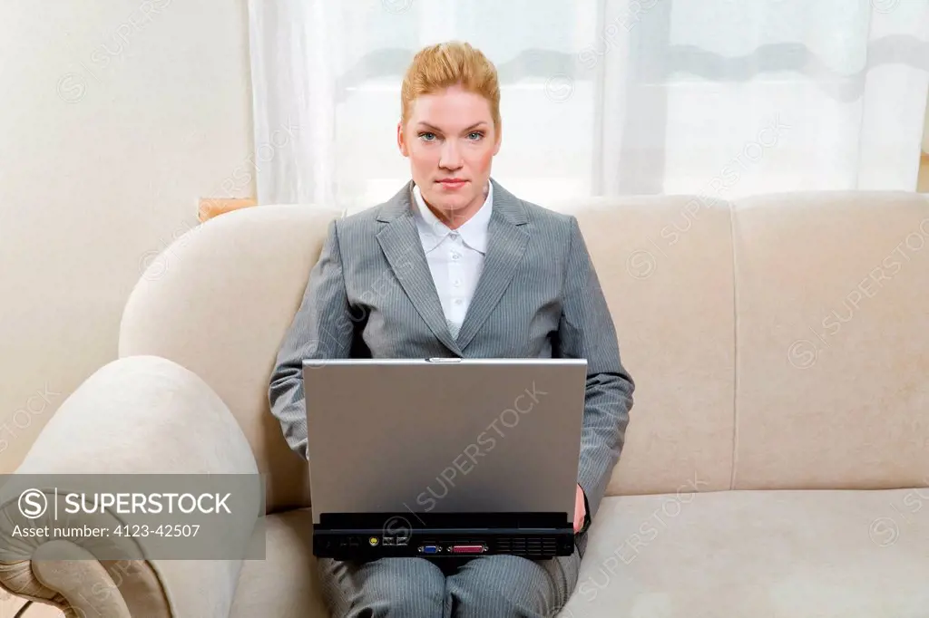 Woman working at home, using her laptop.