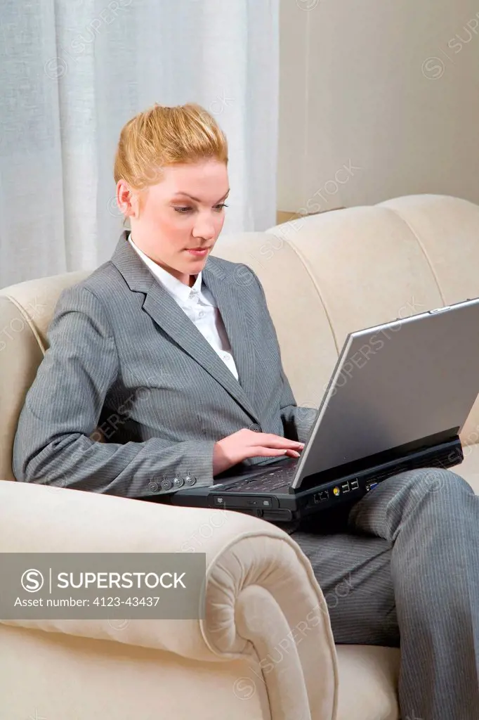 Woman working at home, using her laptop.