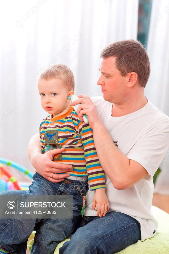 Man measuring his son's temperature.