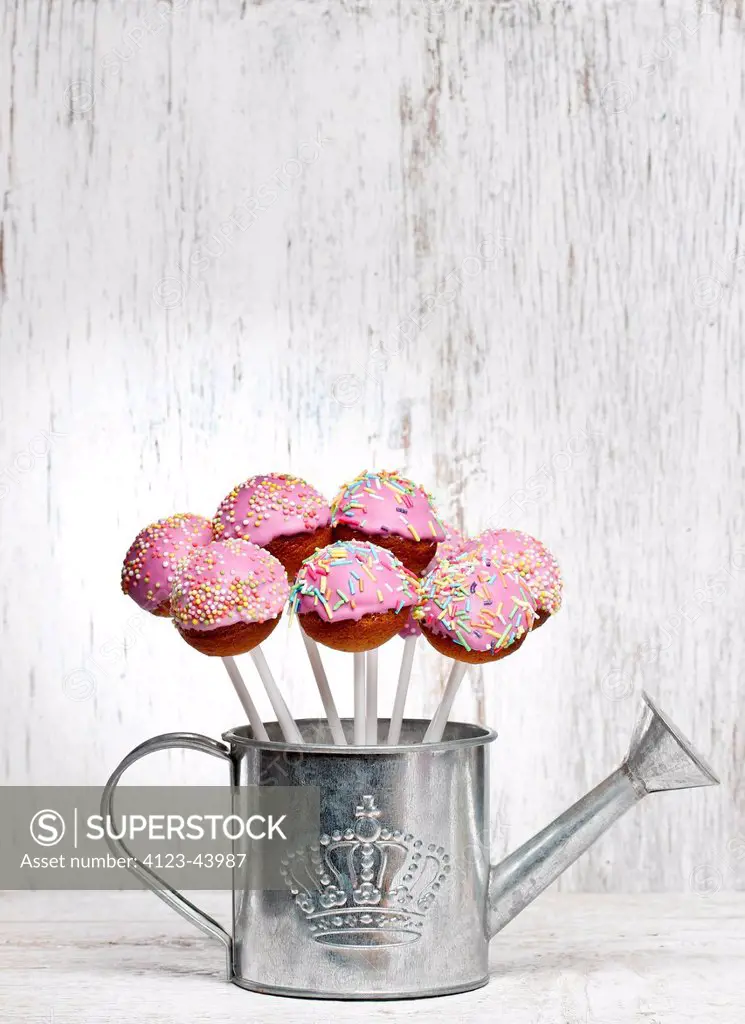 Cake pops on sticks with sugar-icing.