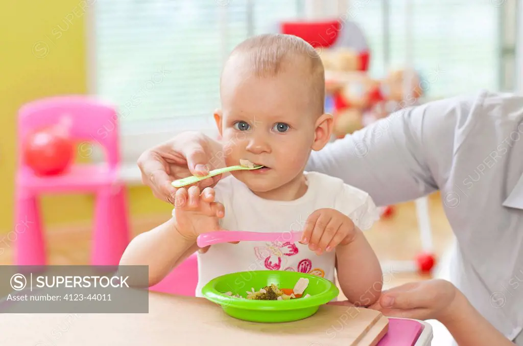 Adorable baby girl eating some vegetables.