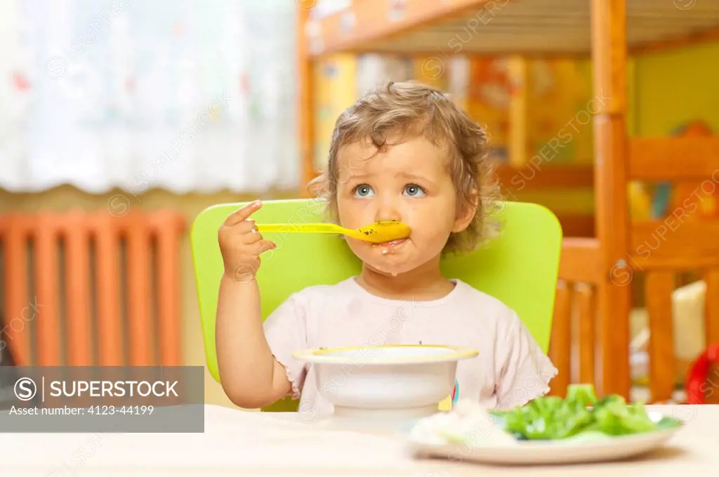 Little girl eating soup.