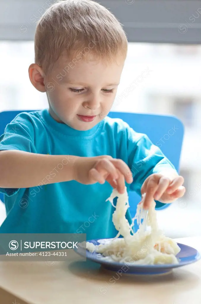 Six year old boy eating sauerkraut.