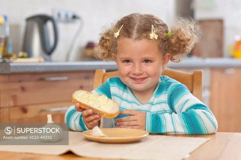 Adorable girl eating sadwich with garlic.
