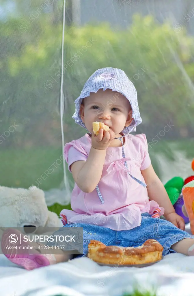Baby girl at a picnic in the garden.