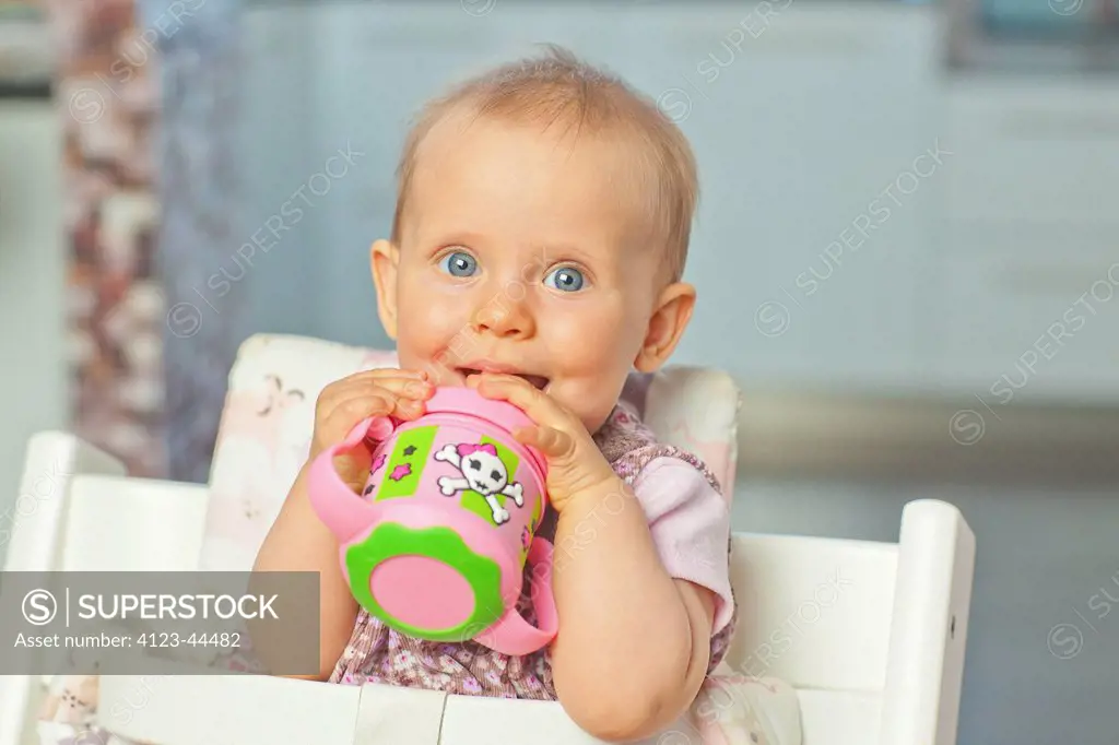 Cute little girl drinking water from cup.