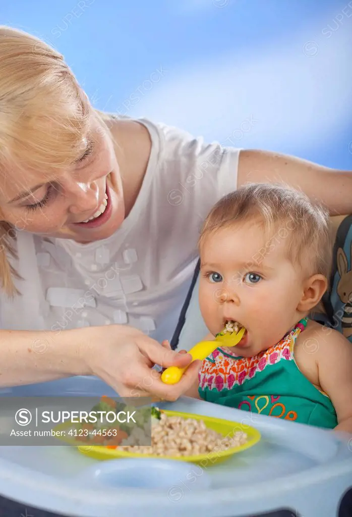 Woman feeding her baby girl.