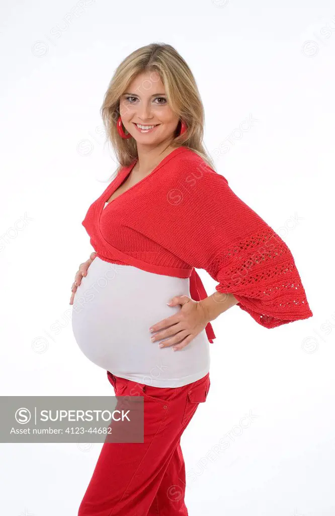 Young pregnant woman with hands on her tummy.