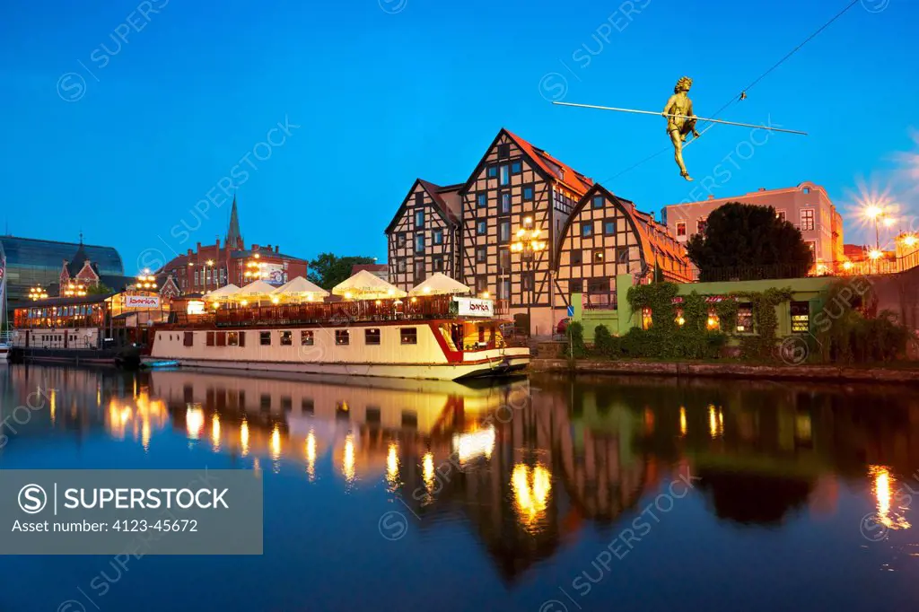 Poland, Kujawy-Pomerania Province, Bydgoszcz. Ferry on Brda river, historic granaries.