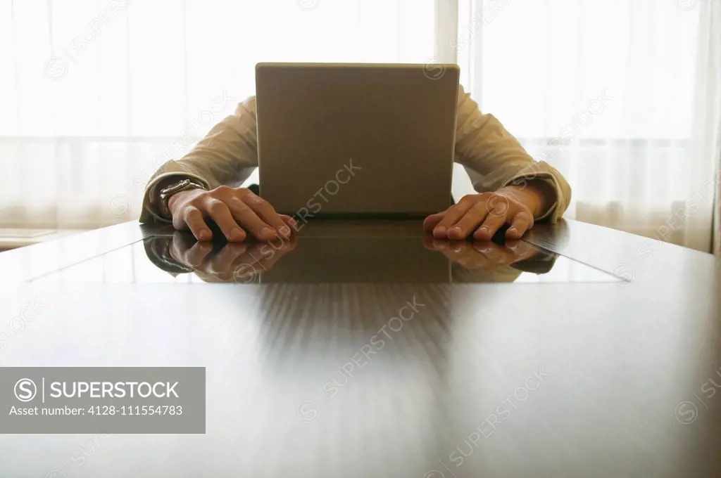 Businessman behind laptop
