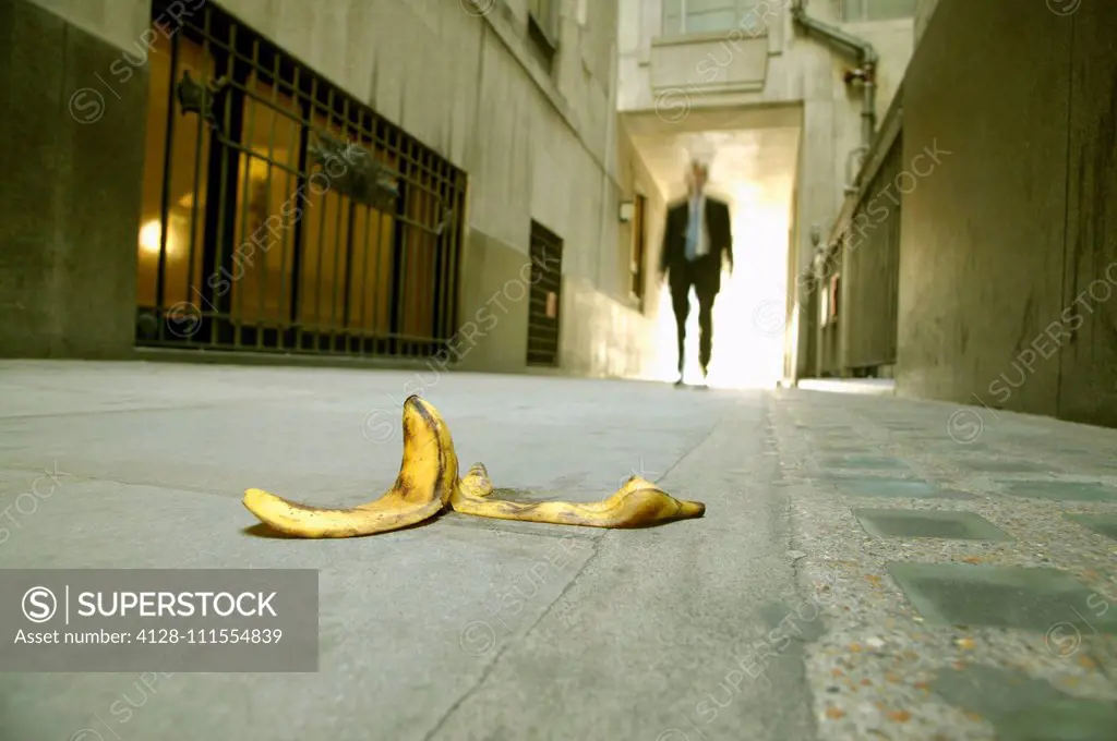 Businessman walking towards banana skin