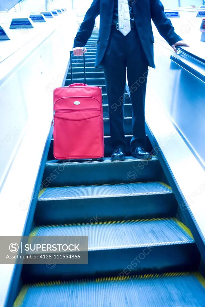 Businessman travelling down an escalator