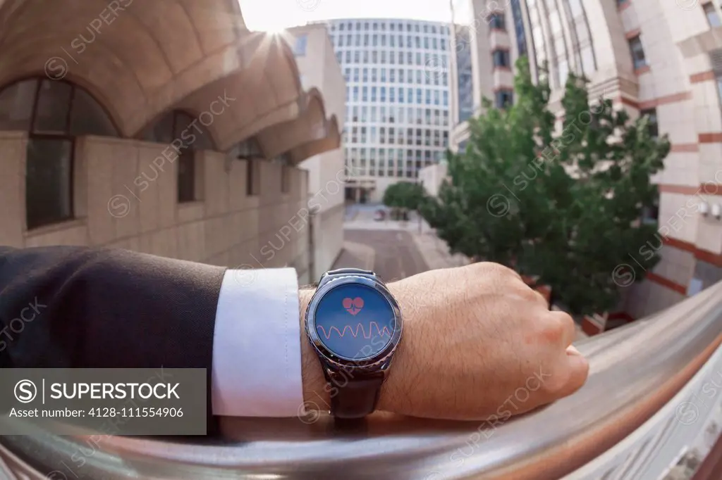 Businessman taking his pulse on a smartwatch