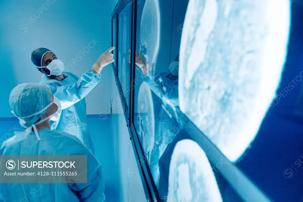Surgeons looking at MRI scans during surgery