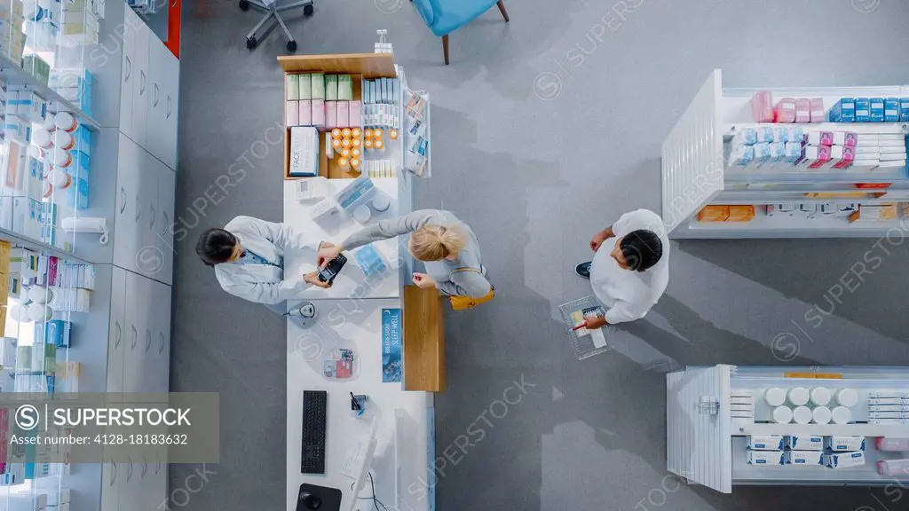 Pharmacist and customers at a counter in a pharmacy