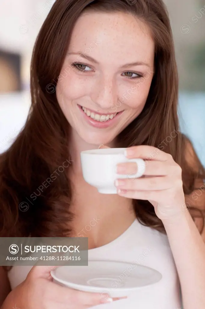 MODEL RELEASED. Young woman drinking coffee.