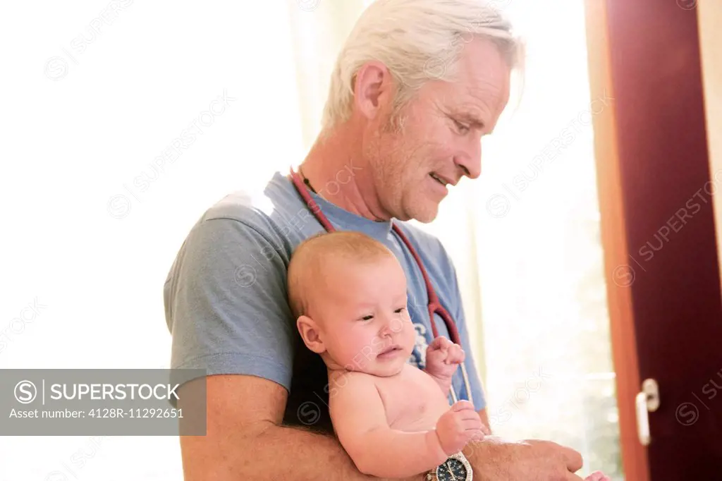 MODEL RELEASED. Portrait of a doctor holding a baby.