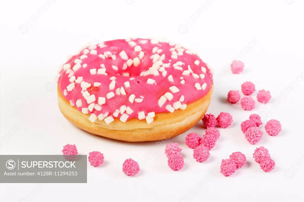 Doughnut with pink decorations, studio shot.