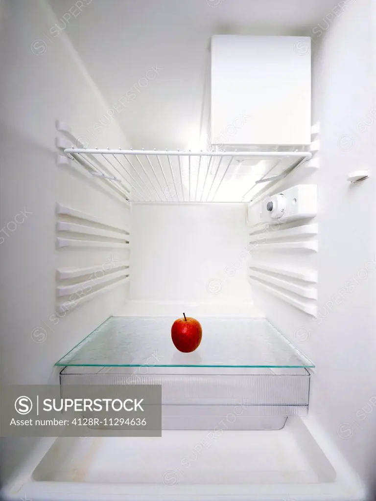 Red apple in an empty fridge.
