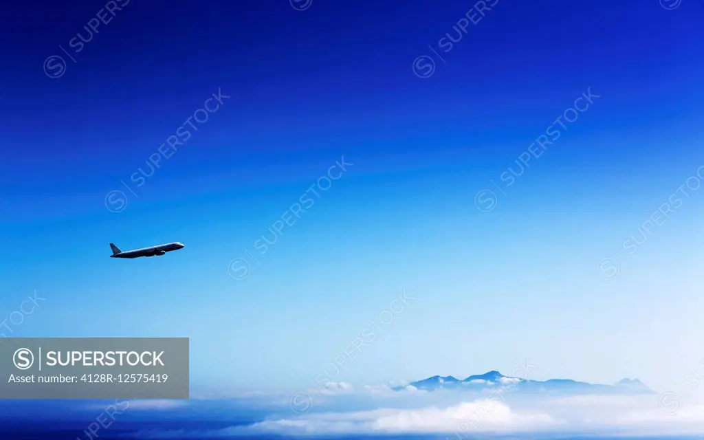 Aeroplane flying in a clear blue sky.