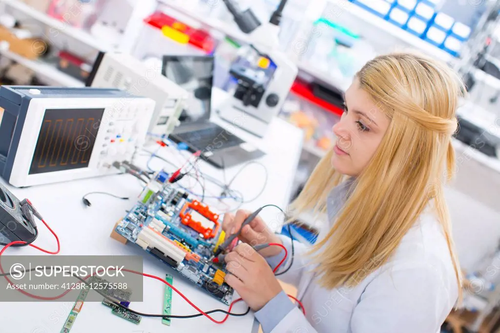 Laboratory assistant using a circuit board.