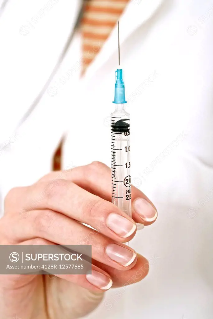 Person holding a syringe, close up.