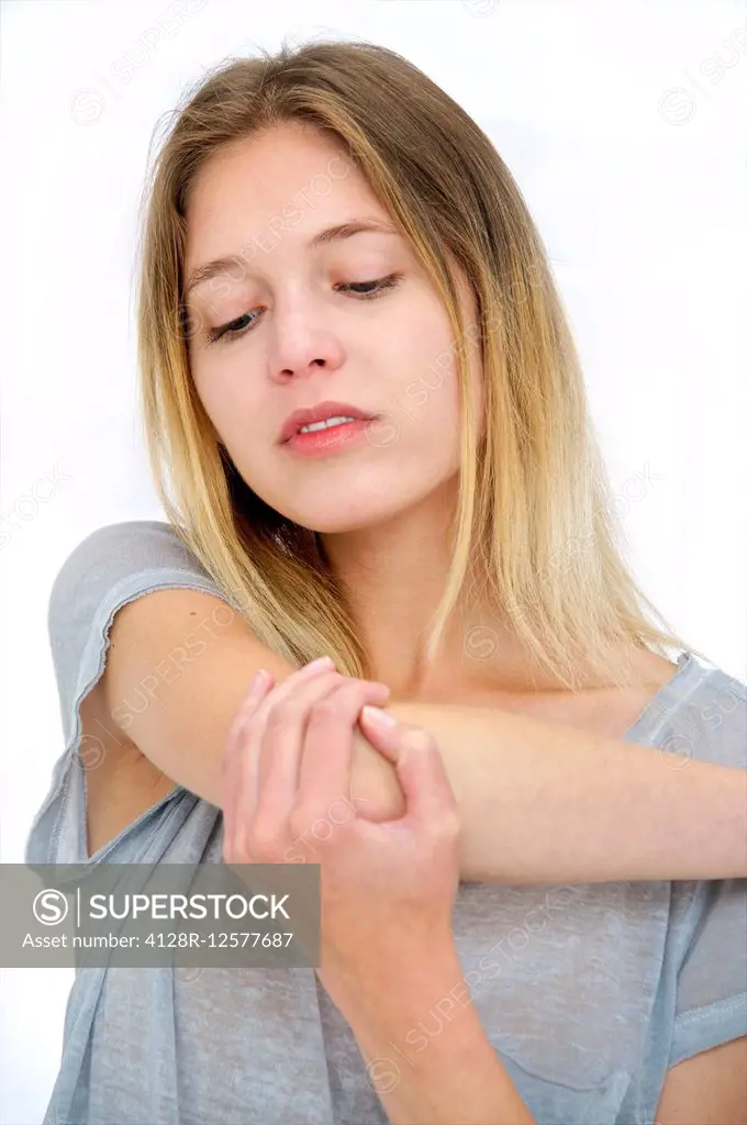 Young woman touching her elbow.
