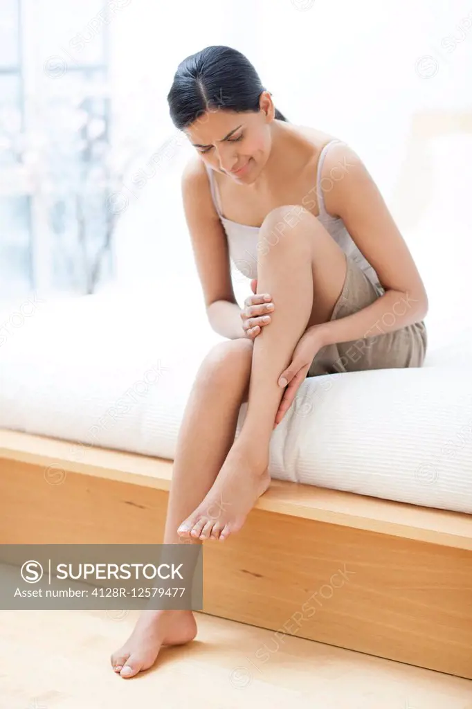 Young woman rubbing her leg.