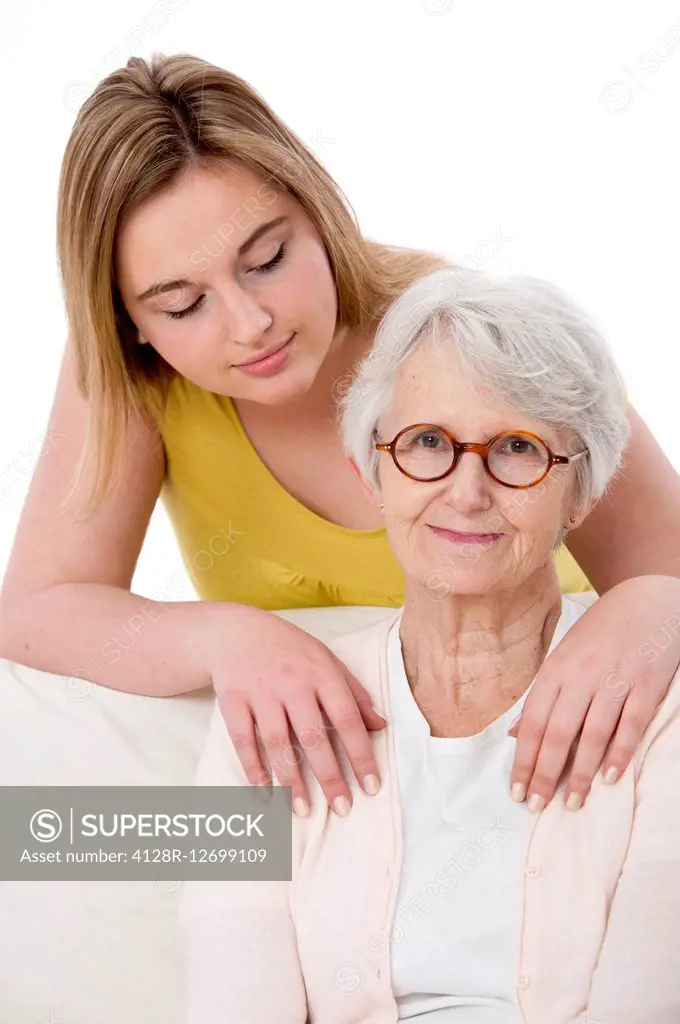 MODEL RELEASED. Young woman with her hands on the shoulders of a senior woman.
