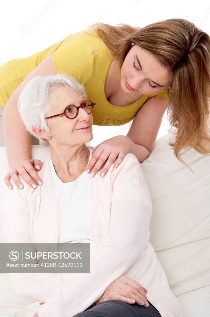 MODEL RELEASED. Young woman with her hands on the shoulders of a senior woman.