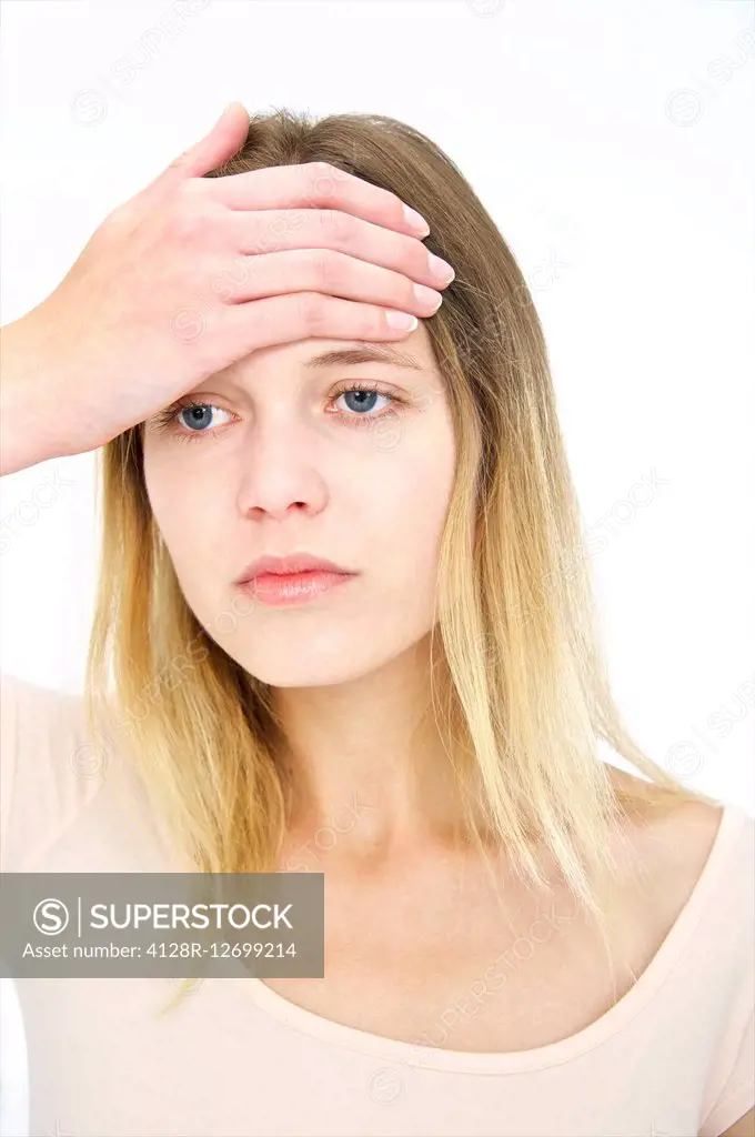MODEL RELEASED. Young woman with her hand on her forehead.