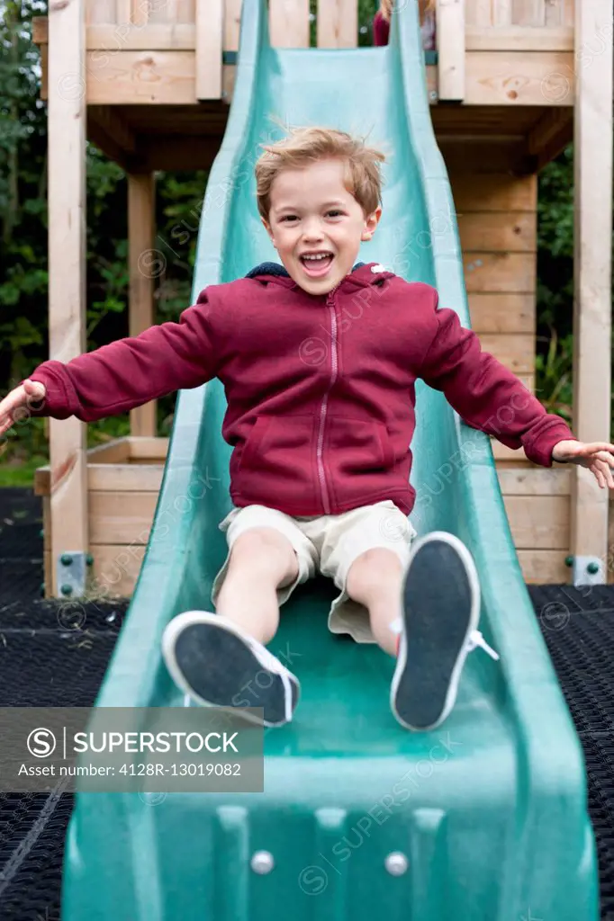 MODEL RELEASED. Boy sliding down a slide.