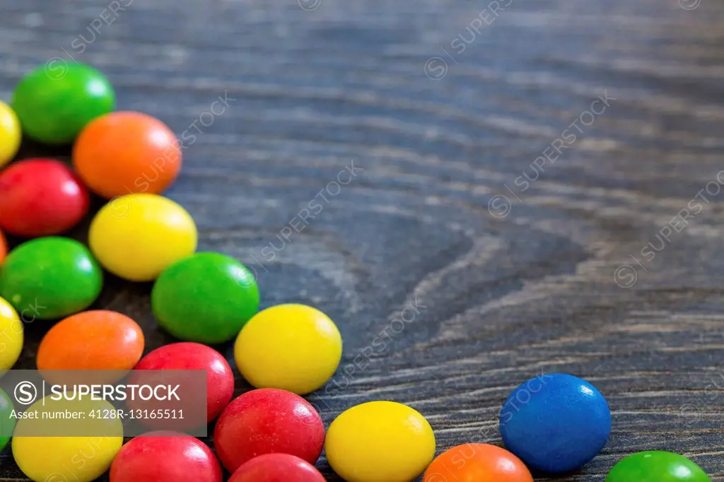 Colourful sweets on a wooden surface.