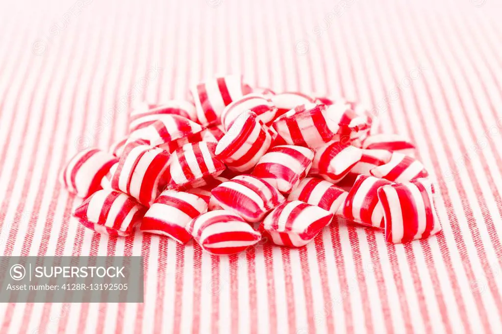 Red and white sweets on striped background.