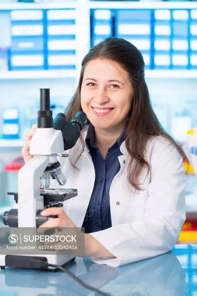 Young woman using microscope in the laboratory.