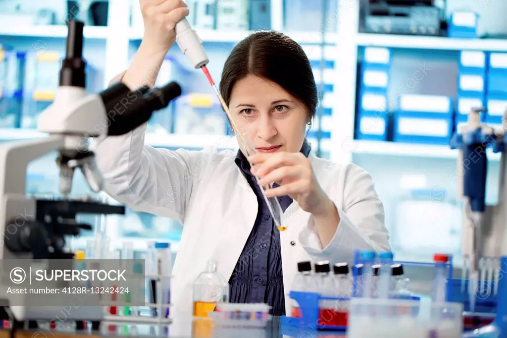 Female laboratory technician using a pipette.