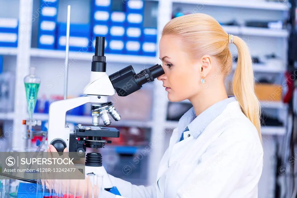 Female scientist using microscope in the laboratory.