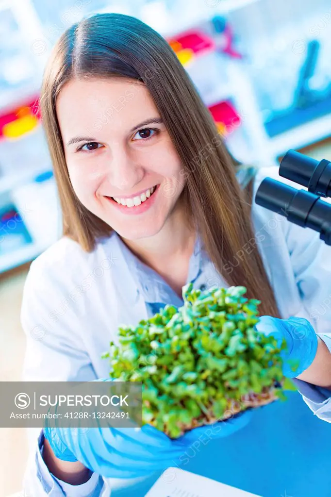 Female biologist holding tray of seedlings.