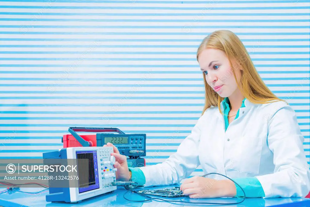 Laboratory assistant testing a printed circuit board.