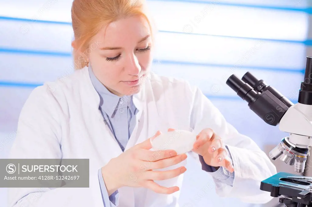 Female lab technician holding a petri dish.