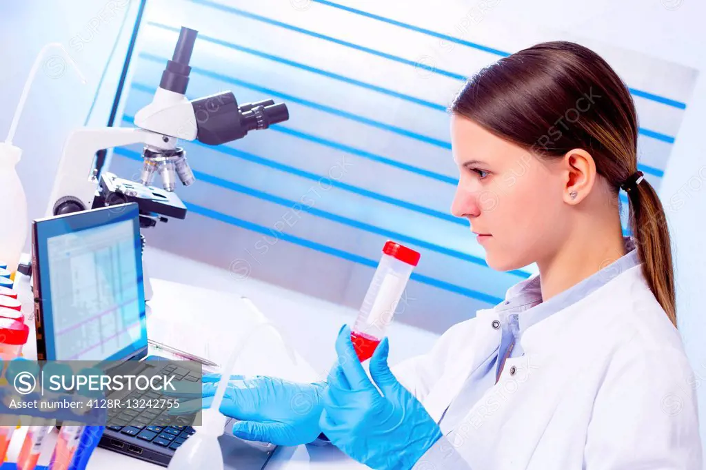 Female lab technician holding test tube in laboratory.
