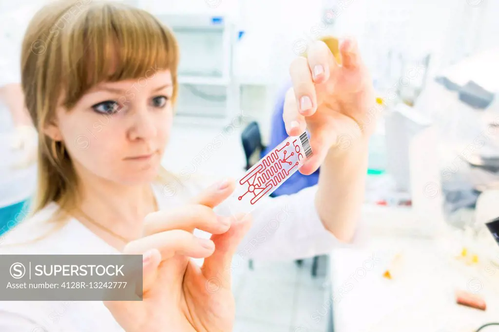 Female lab technician holding a lab on a chip.