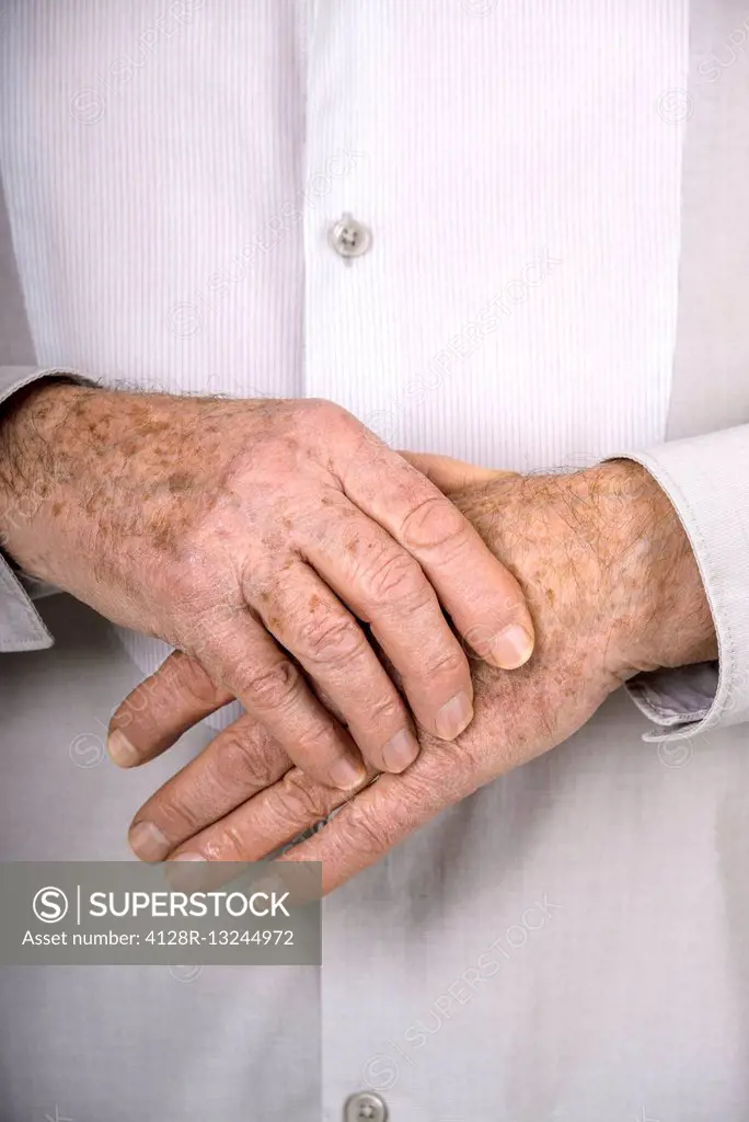 MODEL RELEASED. Senior man holding his hand.