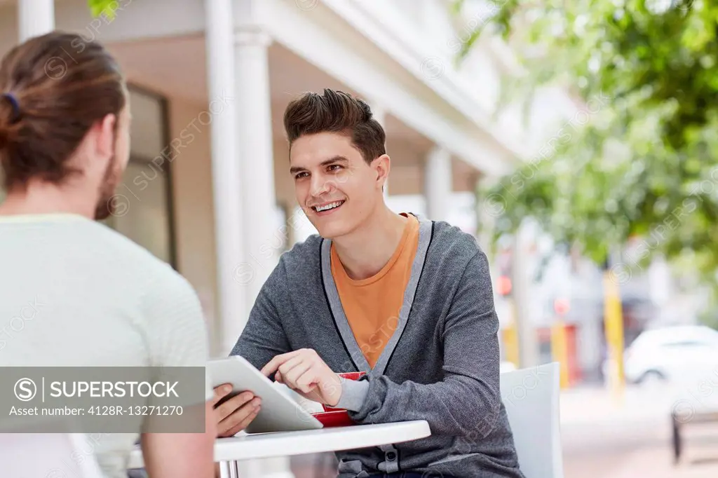 MODEL RELEASED. Two young male friends with digital tablet.