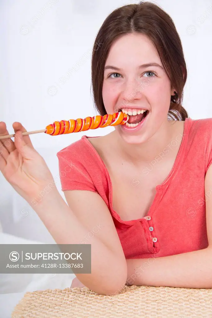 MODEL RELEASED. Teenage girl eating lollipop.