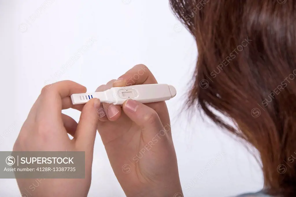 MODEL RELEASED. Teenage girl doing a pregnancy test.
